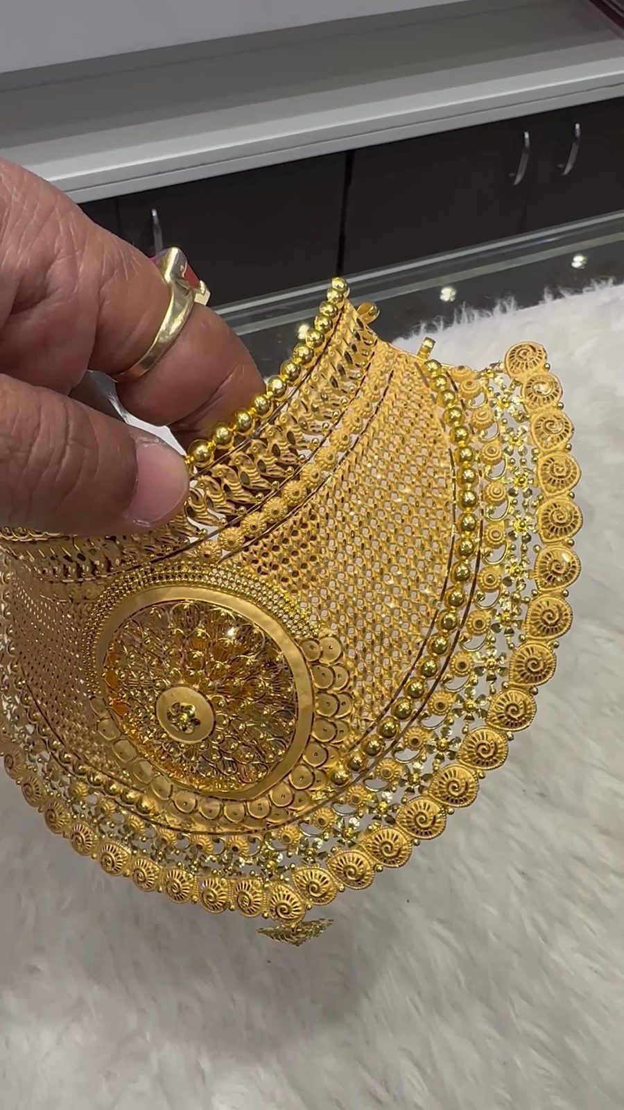 A gold choker held at the counter
